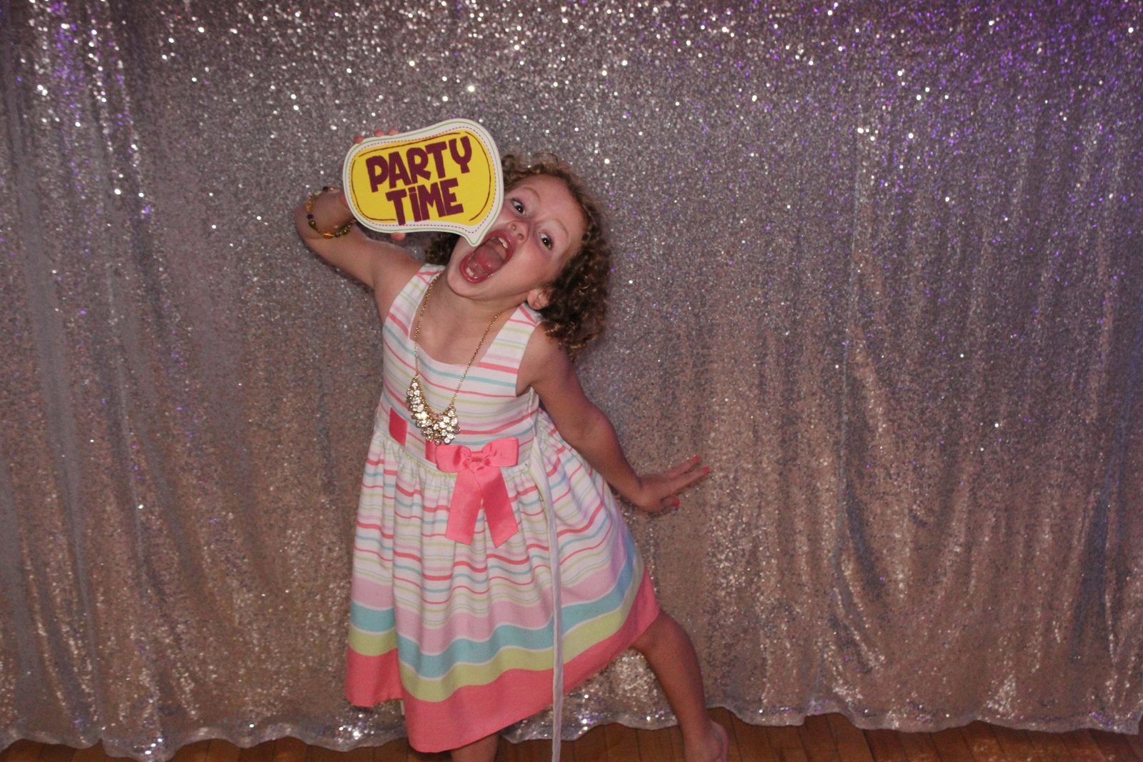 Little girl with a Party Time sign at a birthday photo booth