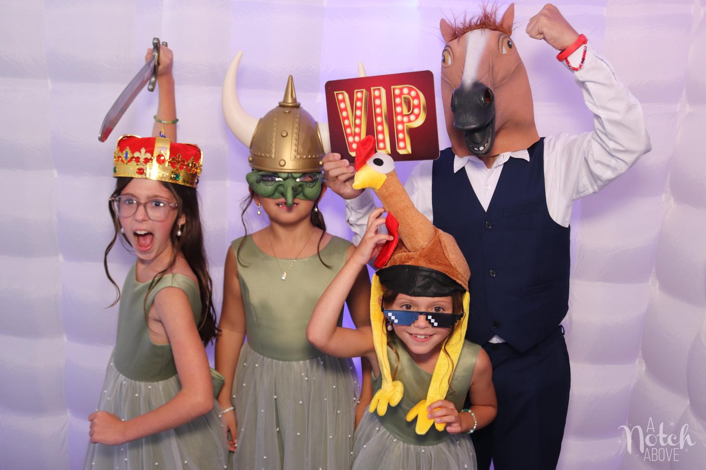 Flower girls and a guest in a horse mask hamming it up with props in the LED cube